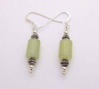 Jade oval cylinders with silver beads strung on silver wire.