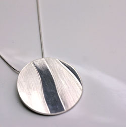 round silver pendant with texture