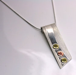 scimiter shape silver pendant with copper and brass